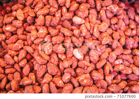 Almondsts in a sugar crust at the grocery market. Sugar roasted almonds (Selective focus) 71077600