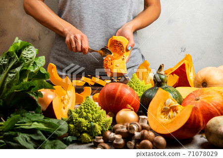 Female hands peels pumpkin on the kitchen. Vegetarian healthy food concept. close-up Female hands peels pumpkin on the kitchen. Vegetarian healthy food concept. close-up 71078029