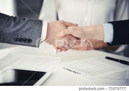 Business people shaking hands finishing contract signing, close-up. Business communication concept. Handshake and marketing Business people shaking hands finishing contract signing, close-up. Business communication concept. Handshake and marketing 71078777