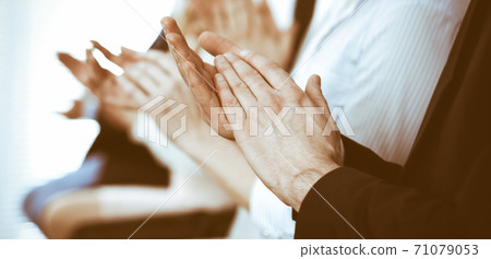 Business people clapping and applause at meeting or conference, close-up of hands. Group of unknown businessmen and women in modern white office. Success teamwork or corporate coaching concept Business people clapping and applause at meeting or conference, close-up of hands. Group of unknown businessmen and women in modern white office. Success teamwork or corporate coaching concept 71079053