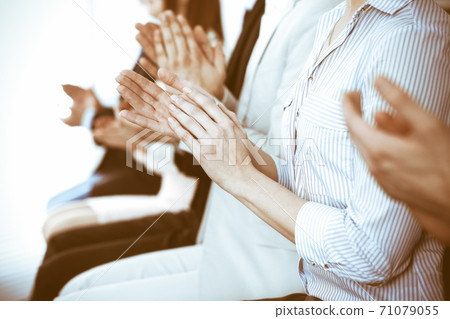 Business people clapping and applause at meeting or conference, close-up of hands. Group of unknown businessmen and women in modern white office. Success teamwork or corporate coaching concept Business people clapping and applause at meeting or conference, close-up of hands. Group of unknown businessmen and women in modern white office. Success teamwork or corporate coaching concept 71079055