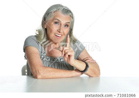 Emotional senior woman pointing isolated on white background Emotional senior woman pointing isolated on white background 71081066