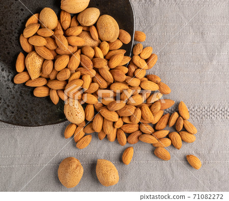 Heap of Raw Almonds on Rustic Background Closeup Heap of Raw Almonds on Rustic Background Closeup 71082272