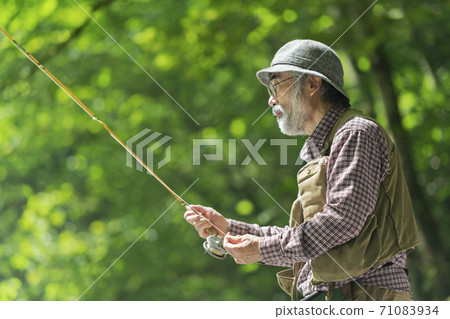 Senior man enjoying fishing Senior man enjoying fishing 71083934