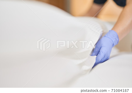 Female hands adjusting the pillow in hotel room 71084187