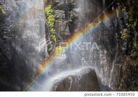 Rainbow over waterfall 71085450