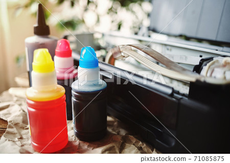 Refilling printer cartridges with multi-colored ink. Background 71085875