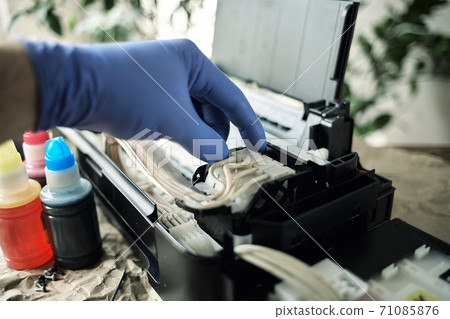 Refilling printer cartridges with multi-colored ink. Background 71085876