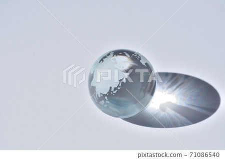 Light shines into an earth figurine made of glass 71086540