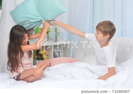 Cute children playing with pillows with at home Cute children playing with pillows with at home 71086907