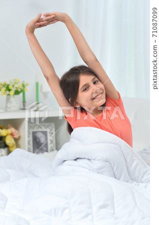 Cute little girl waking up in bed Cute little girl waking up in bed 71087099