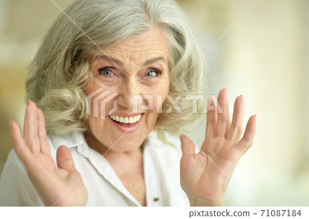 Portrait of happy senior woman posing at home 71087184