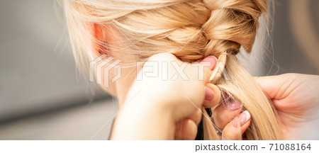 Female hands braiding pigtail to woman Female hands braiding pigtail to woman 71088164