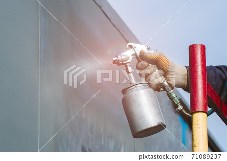 Metal surface painting. Hand with a compressor pultilizer close-up. 71089237