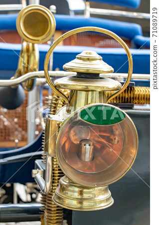 The headlight of the old car. Veteran car with large golden light, close up. 71089719