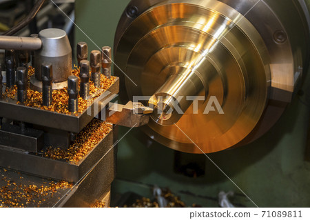 The operation of lathe machine cutting the brass material parts with the cutting tools. The operation of lathe machine cutting the brass material parts with the cutting tools. 71089811