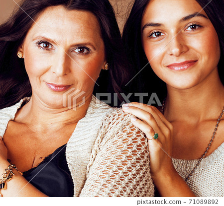 cute pretty teen daughter with mature mother hugging, fashion style brunette makeup together, warm colors cute pretty teen daughter with mature mother hugging, fashion style brunette makeup together, warm colors 71089892