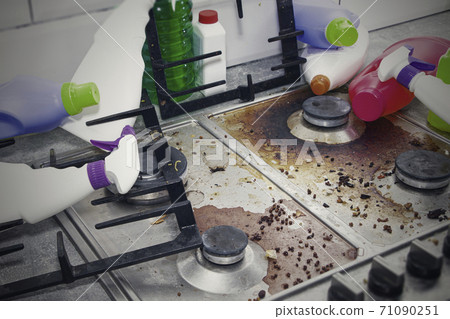 dirty kitchen stove, empty and full bottles of detergents around. dirty kitchen stove, empty and full bottles of detergents around. 71090251