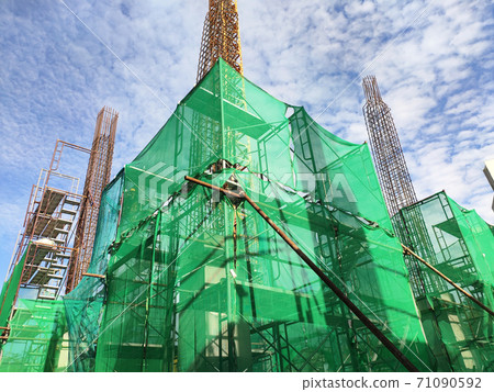 SHAH ALAM, MALAYSIA -AUGUST 6, 2020: Temporary staircase and scaffolding are used in the construction of high concrete columns. Scaffolding is wrapped with safety netting for safety purposes. Installe SHAH ALAM, MALAYSIA -AUGUST 6, 2020: Temporary staircase and scaffolding are used in the construction of high concrete columns. Scaffolding is wrapped with safety netting for safety purposes. Installe 71090592