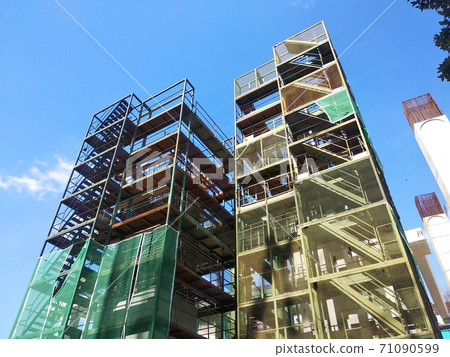 SHAH ALAM, MALAYSIA -AUGUST 6, 2020: Temporary staircase and scaffolding are used in the construction of high concrete columns. Scaffolding is wrapped with safety netting for safety purposes. Installe 71090599