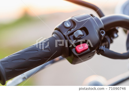 Red horn switch. Left handle bar with hand clutch of motorcycle. Motorcycle maintenance concept outdoor shooting with sunset effect 71090746