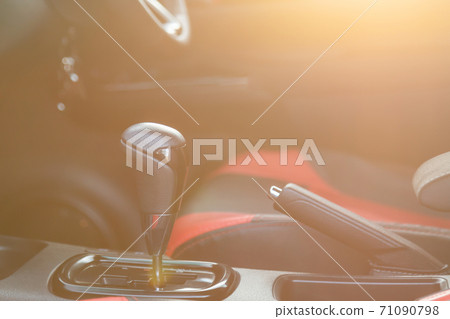 Close up driver automatic gear stick inside the modern car. Car interior with morning golden sun light flare effectterior with morning golden sun light flare effect. Transportation use 71090798