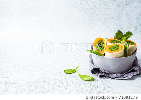 Vegan tortilla wraps with sweet potato and spinach, gray background. Healthy vegetarian food concept. Vegan tortilla wraps with sweet potato and spinach, gray background. Healthy vegetarian food concept. 71091179
