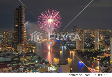 Happy New Year Fireworks Festival Event at Taksin bridge with Chao Phraya River in Bangkok, Thailand. Financial district and skyscraper buildings. Downtown skyline at night. 71091362