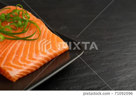 Slices of Raw Salmon Fillet on Black Background Slices of Raw Salmon Fillet on Black Background 71092096