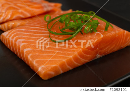 Slices of Raw Salmon Fillet on Black Background Slices of Raw Salmon Fillet on Black Background 71092101