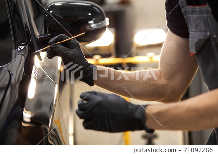 cropped caucasian auto service worker is painting car details cropped caucasian auto service worker is painting car details 71092286