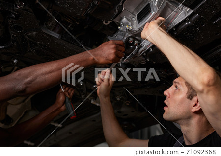 view from below on men repairing car bottom view from below on men repairing car bottom 71092368