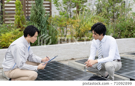 A businessman inspecting a solar panel A businessman inspecting a solar panel 71092899