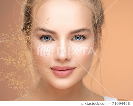 Portrait of young beautiful woman with a healthy  skin of face.  Attractive girl with a bunch spring field flowers 71094468