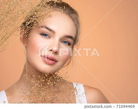 Portrait of young beautiful woman with a healthy skin of face. Attractive girl with a bunch spring field flowers Portrait of young beautiful woman with a healthy skin of face. Attractive girl with a bunch spring field flowers 71094469