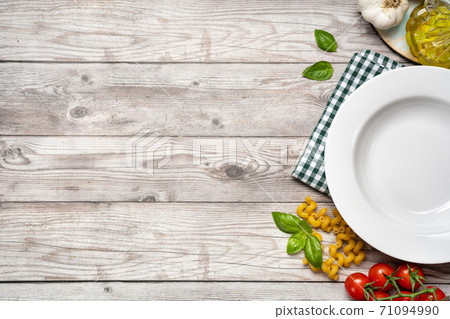 Food cooking background with vegetables, pasta and empty white plate Food cooking background with vegetables, pasta and empty white plate 71094990