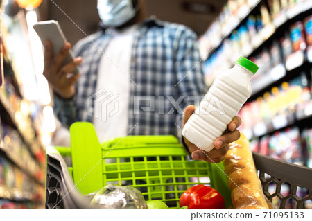 Black Man In Mask Using Smartphone Buying Food In Supermarket Black Man In Mask Using Smartphone Buying Food In Supermarket 71095133