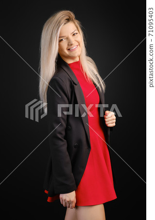 Pretty woman in red dress and black jacket posing 71095403