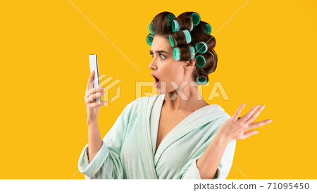 Shocked Housewife Holding Phone Reading Shocking Message, Yellow Background, Panorama 71095450