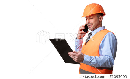 Builder In Uniform Talking On Phone Standing On White Background Builder In Uniform Talking On Phone Standing On White Background 71095603