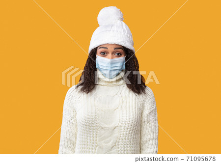 Portrait of black lady in medical mask and winter hat Portrait of black lady in medical mask and winter hat 71095678