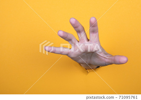 Hand reaches for help. Yellow paper background. Copy space Hand reaches for help. Yellow paper background. Copy space 71095761