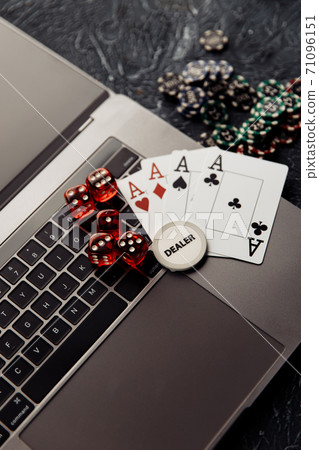 Online casino. Gambling chips, cards with aces and red dices on laptop keyboard. Vertical image Online casino. Gambling chips, cards with aces and red dices on laptop keyboard. Vertical image 71096151