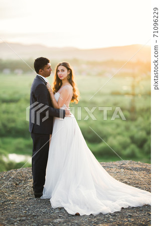 Sunshine portrait of happy bride and groom outdoor in nature location Sunshine portrait of happy bride and groom outdoor in nature location 71096229