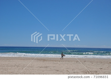Surfers heading to the waters of the Gold Coast 71096831