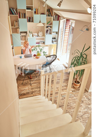 Middle aged caucasian business woman sitting at kitchen table 71099204