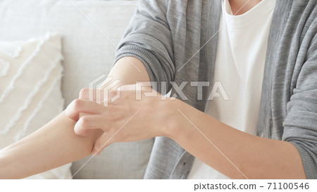 A man scratching his arm 71100546