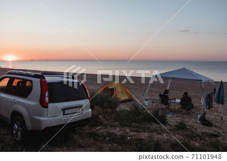 camping site at sandy beach. people sitting and looking on sunset camping site at sandy beach. people sitting and looking on sunset 71101948