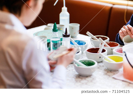 A young woman experiencing pottery painting 71104525