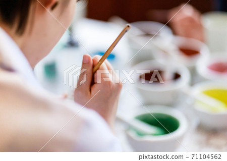 一位年輕女子正在陶器繪畫 一位年輕女子正在陶器繪畫 71104562